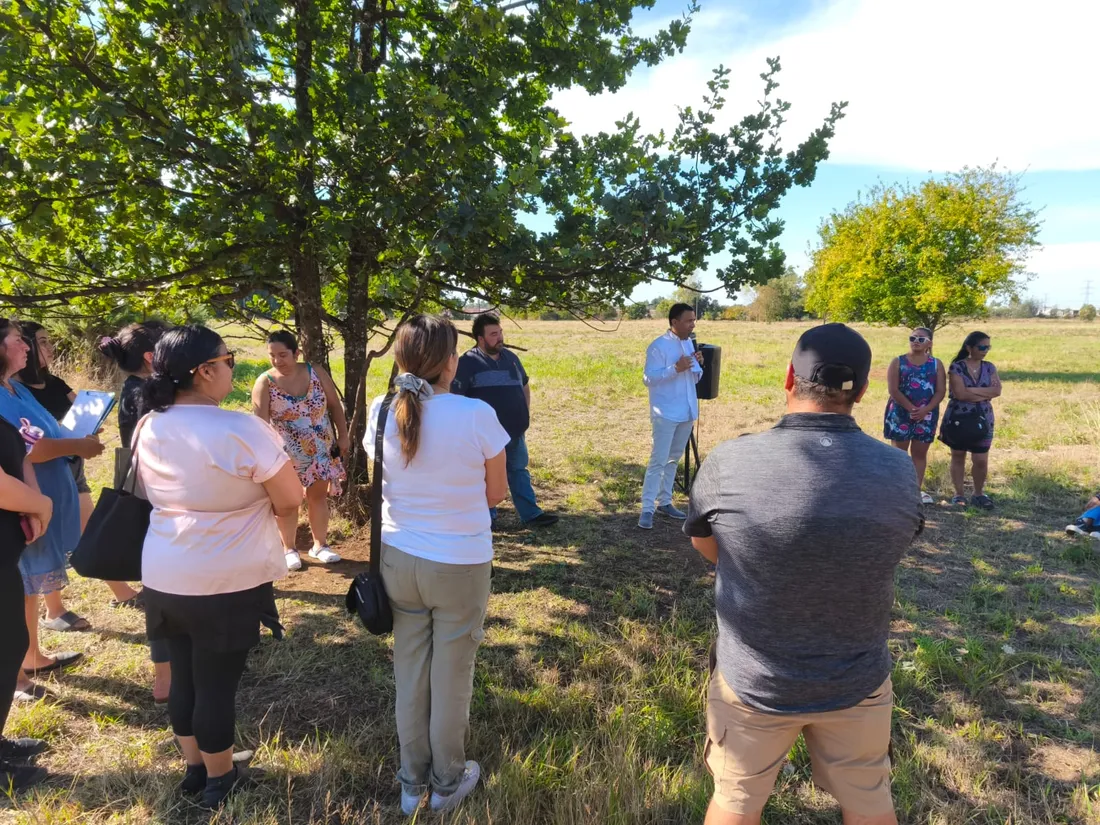 Encuentro al aire libre con una comunidad, junto a árboles